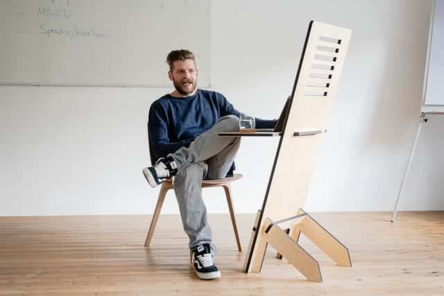 man sitting at sit to stand converter