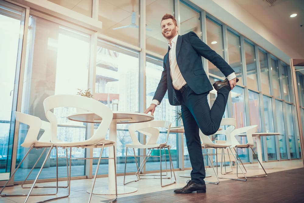 man stretching leg at office