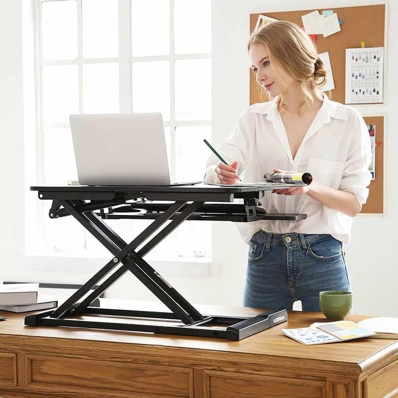 female standing beofre flexispot desk converter