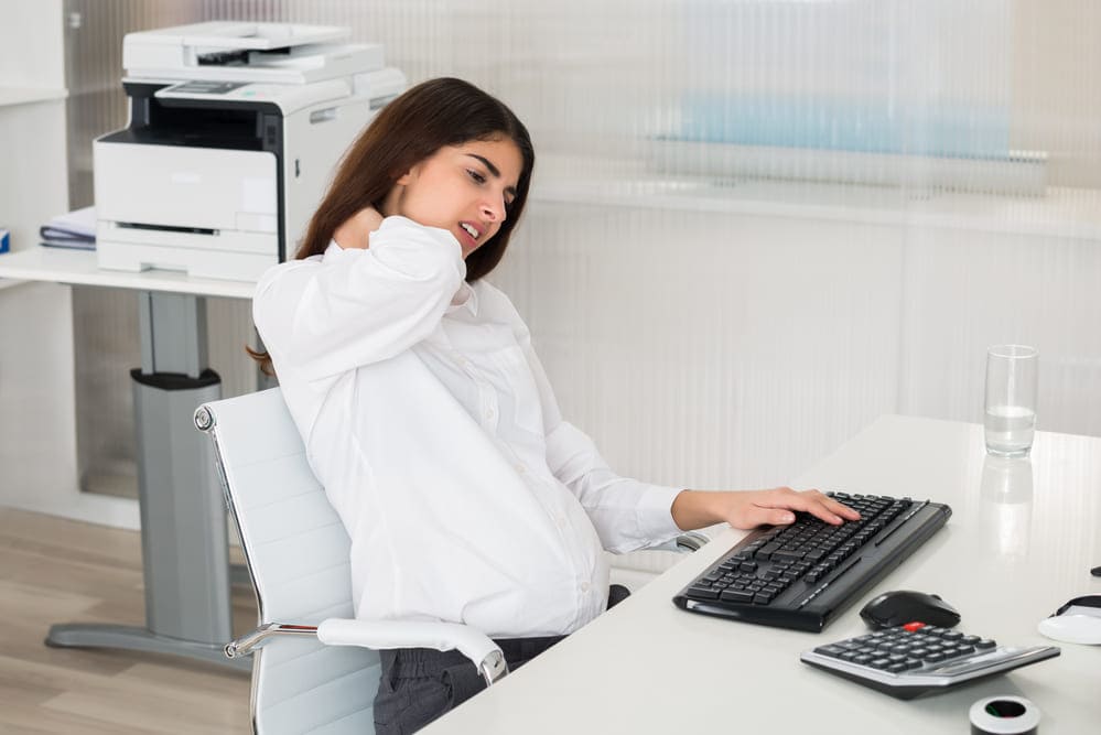 woman sitting at desk with neck pain