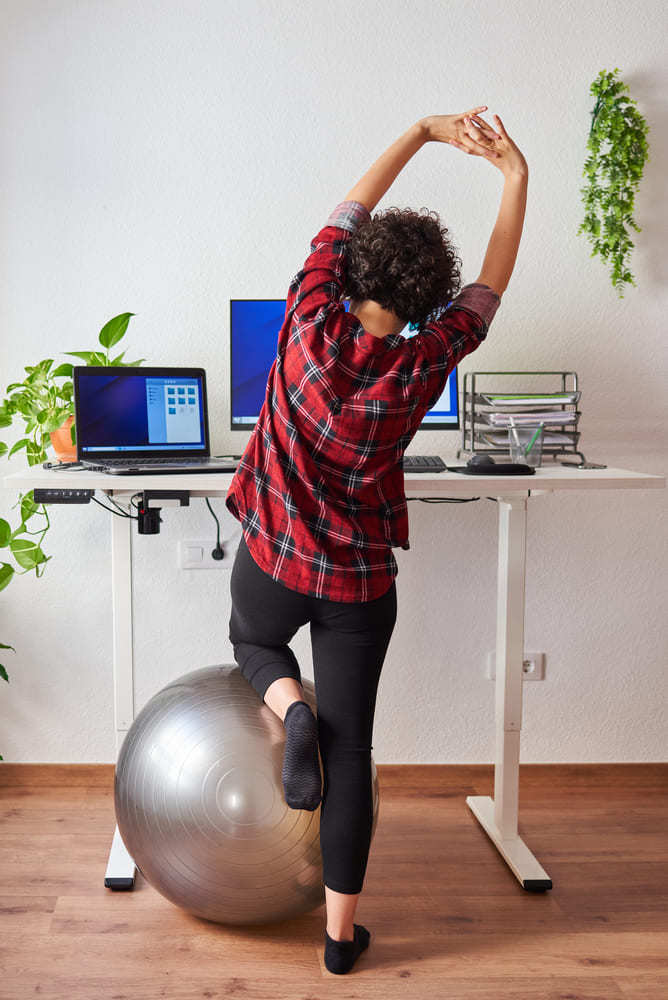 woman stretching in front of standing desk