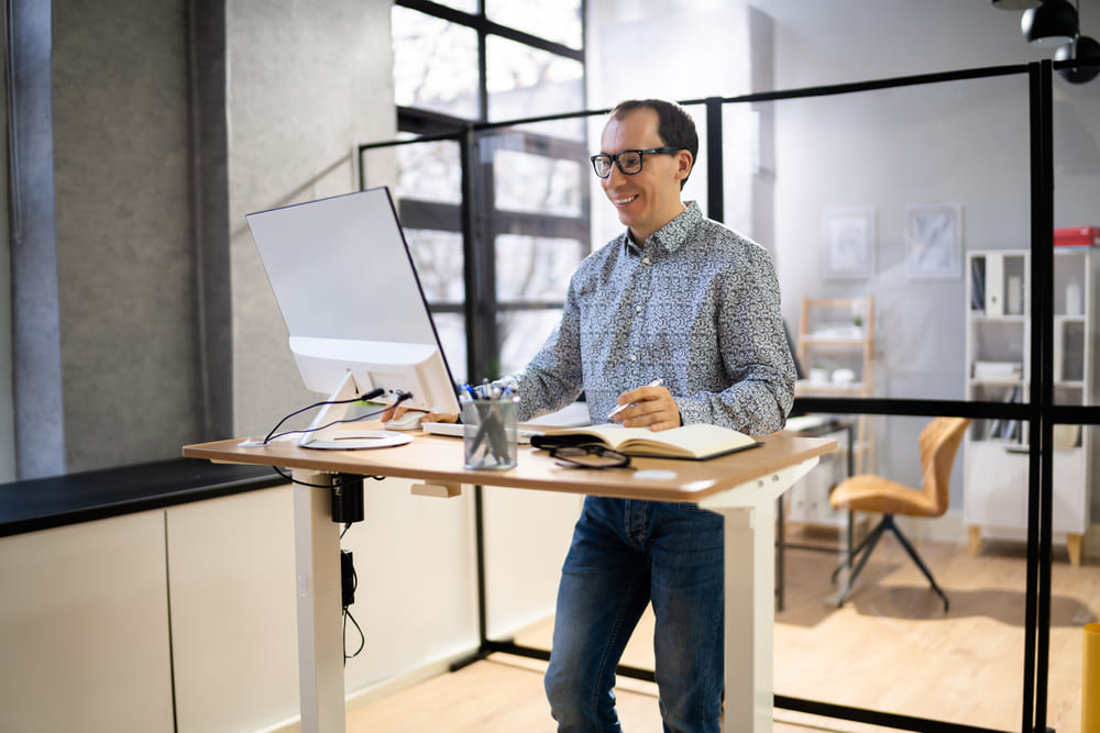 how to get a standing desk at work featured image, man in office