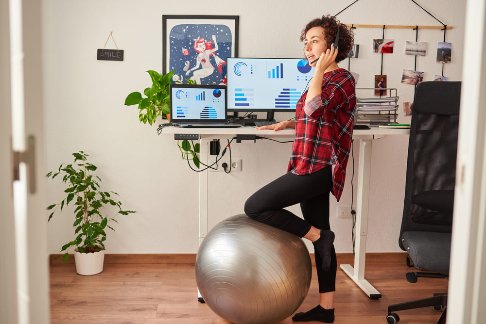 woman in front of standing desk using headset