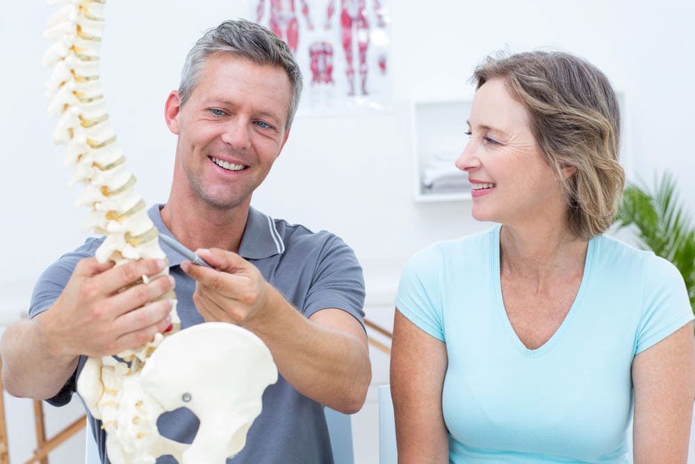 chiropractor showing spine to patient